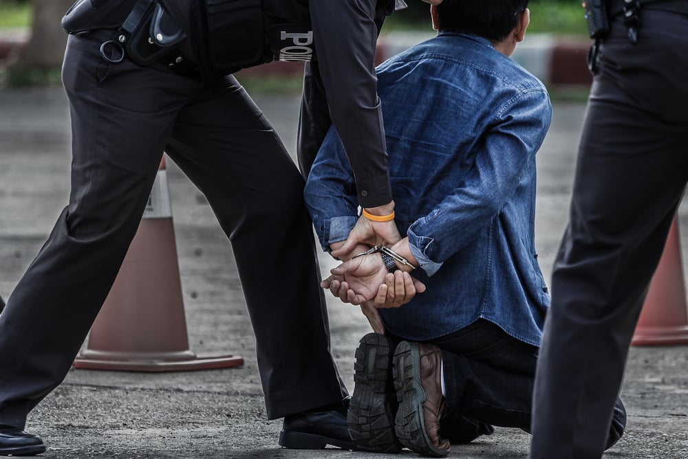 an individual being handcuffed by a police officer