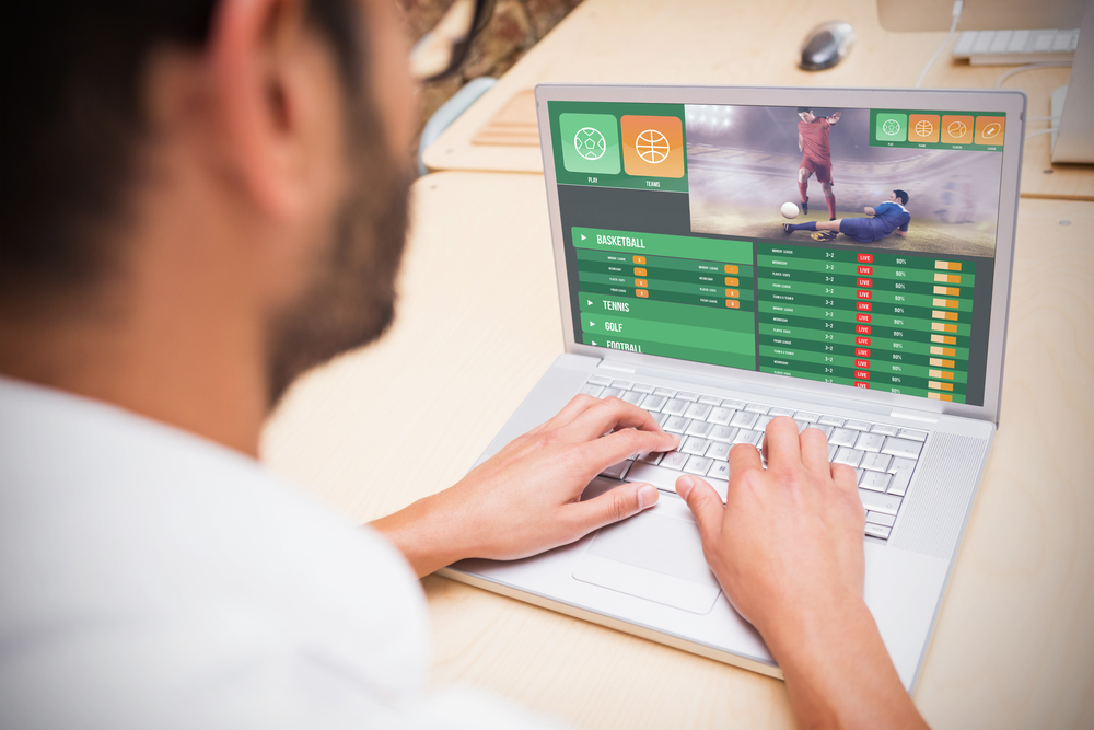 man betting on soccer on laptop