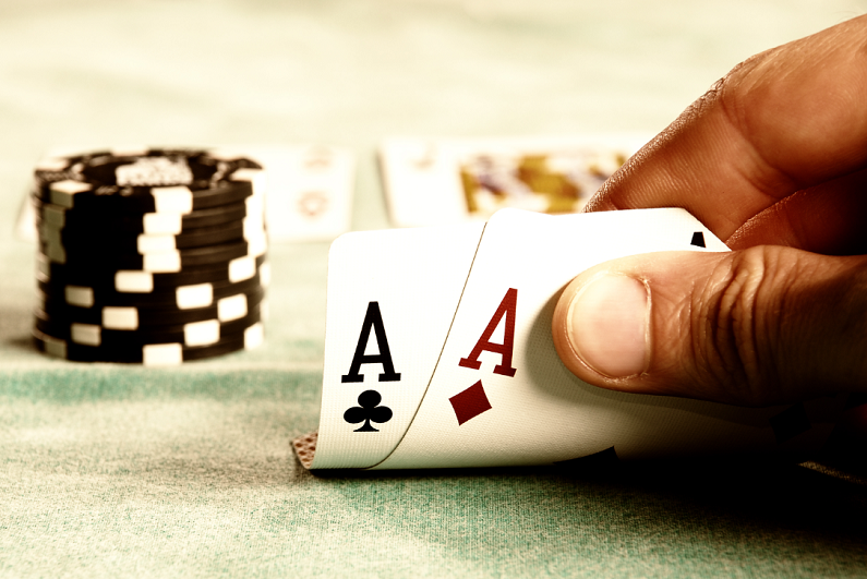 poker player looking at pocket aces