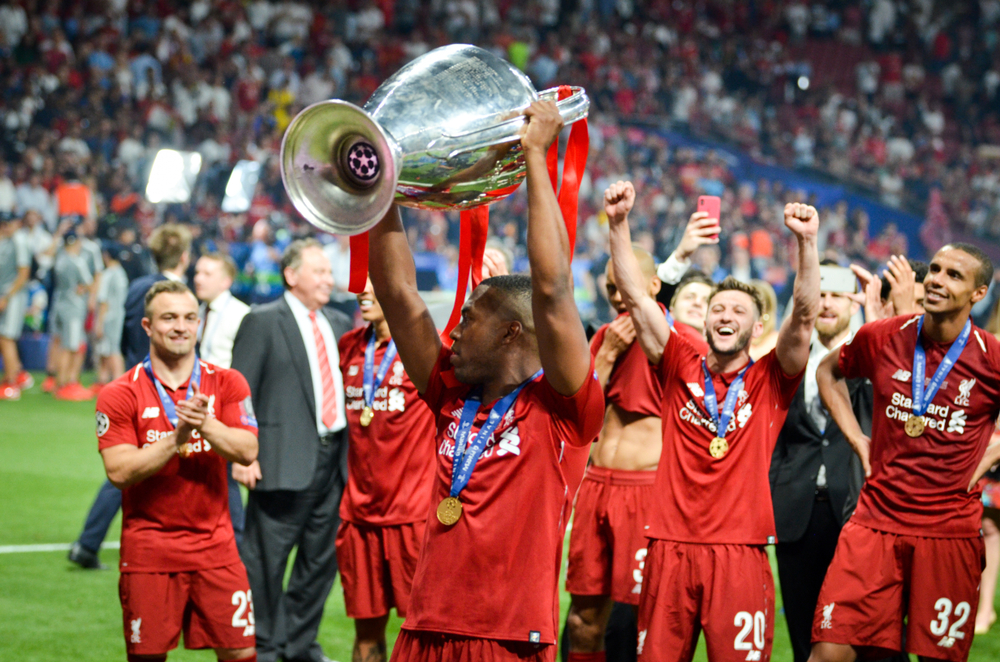 Daniel Sturridge celebrating team win while holding victory cup