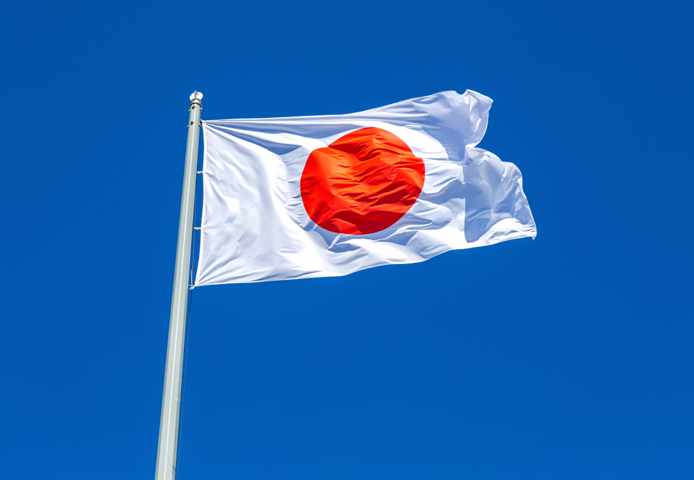 flag of Japan on a mast against a blue sky backdrop