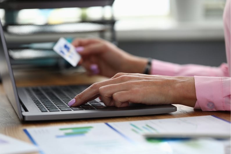 Women entering her credit card info on a laptop