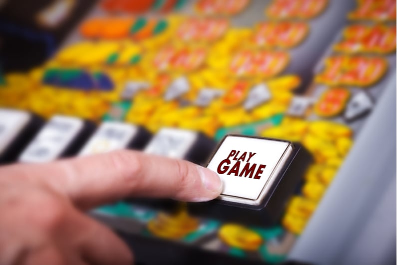 hand presses play game button on slot machine